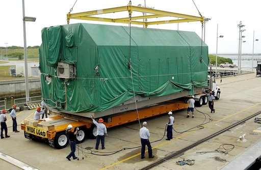 KENNEDY SPACE CENTER, FLA. - At Port Canaveral, the Pressurized Module of the Japanese Experiment Module (JEM) is lowered onto a truck bed for transfer to KSC’s Space Station Processing Facility.  The container transport ship carrying JEM departed May 2 from Yokohama Harbor in Japan for the voyage t