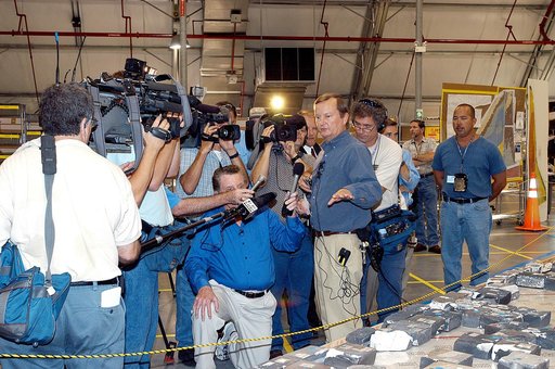 KENNEDY SPACE CENTER, FLA. - In the Columbia Debris Hangar,  Shuttle Launch Director Mike Leinbach  points to some of the tiles recovered from the orbiter as he explains to the media about activities that have taken place since the Columbia accident on Feb. 1, 2003.  STS-107 debris recovery and reco