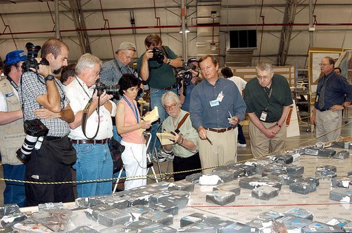 KENNEDY SPACE CENTER, FLA. -  In the Columbia Debris Hangar,  Shuttle Launch Director Mike Leinbach  (center) points to some of the tiles recovered from the orbiter as he explains to the media about activities that have taken place since the Columbia accident on Feb. 1, 2003.  STS-107 debris recover