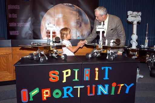 KENNEDY SPACE CENTER, FLA. -  Nine-year-old Sofi Collis (left) is congratulated by NASA Administrator Sean O'Keefe for selecting the names of the Mars Exploration Rovers  -- "Spirit" and "Opportunity" --  during a press conference.  The names Sofi suggested were chosen from more than 10,000 student 