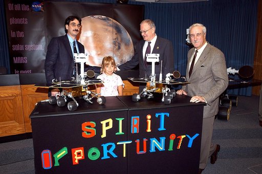 KENNEDY SPACE CENTER, FLA. -  Nine-year-old Sofi Collis poses proudly with a banner displaying the names she selected for the Mars Exploration Rovers -- "Spirit" and "Opportunity" -- during a press conference. Participating in the press conference are, from left, Brad Justus, LEGO Co. senior vice pr