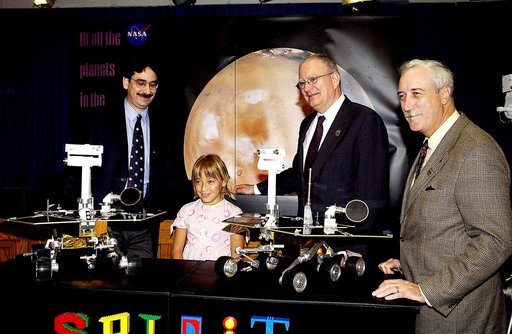 KENNEDY SPACE CENTER, FLA. -  Nine-year-old Sofi Collis poses proudly with a banner displaying the names she selected for the Mars Exploration Rovers -- "Spirit" and "Opportunity" -- during a press conference. Participating in the press conference are, from left, Brad Justus, LEGO Co. senior vice pr