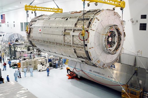 KENNEDY SPACE CENTER, FLA. -   Removed from its shipping canister (lower right), the Japanese Experiment Module (JEM) pressure module is moved across the floor of the Space Station Processing Facility to a work stand.  A research laboratory, the pressurized module is the first element of the JEM, na
