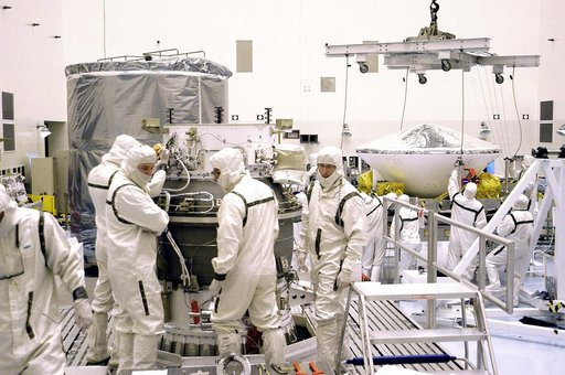 KENNEDY SPACE CENTER, FLA. - In the background, right, workers in the Payload Hazardous Servicing Facility get ready to lift Mars Exploration Rover 1 (MER-B) to the third stage of the Delta rocket (foreground) for mating.  The second of twin rovers being sent to Mars, it is equipped with a robotic a