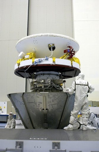 KENNEDY SPACE CENTER, FLA. - Workers in the Payload Hazardous Servicing Facility secure the lower panels of a payload canister around Mars Exploration Rover 1 (MER-B).  The rover will be transported to Launch Complex 17-B, Cape Canaveral Air Force Station, for mating with the Delta rocket.  The seco
