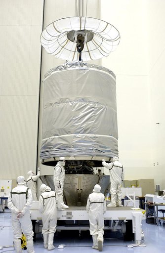 KENNEDY SPACE CENTER, FLA. - In the Payload Hazardous Servicing Facility, workers maneuver the cylindrical payload canister into place around Mars Exploration Rover 1 (MER-B).  Once secure inside the canister, the rover will be transported to Launch Complex 17-B, Cape Canaveral Air Force Station, fo