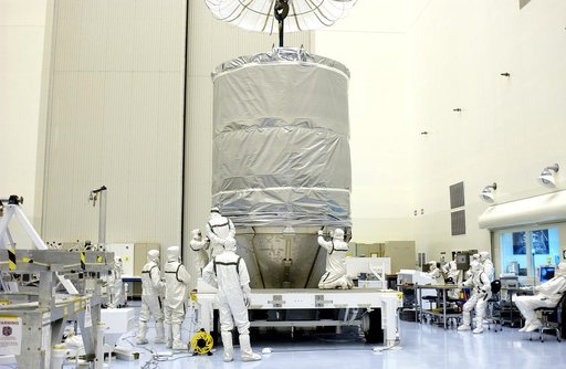 KENNEDY SPACE CENTER, FLA. - In the Payload Hazardous Servicing Facility, workers secure the cylindrical payload canister to the lower panels surrounding Mars Exploration Rover 1 (MER-B).  Once secure inside the canister, the rover will be transported to Launch Complex 17-B, Cape Canaveral Air Force