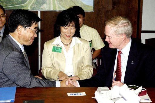KENNEDY SPACE CENTER, FLA. -  Executive Director of NASDA Koji Yamamoto (left) is welcomed to KSC by Center Director Roy Bridges Jr. (right).  On the table between them is the logo of the new Japan Aerospace Exploration Agency, a merger of three Japanese aeronautical and space agencies effective Oct
