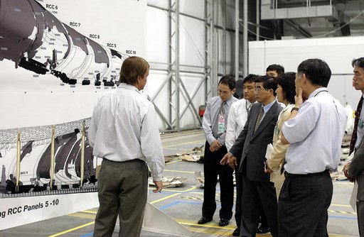 KENNEDY SPACE CENTER, FLA. -    Shuttle Launch Director Mike Leinbach (left) explains recovery and reconstruction efforts of Columbia to the Executive Director of NASDA Koji Yamamoto (second from left) and others visiting the Columbia Debris Hangar.   Mr. Yamamoto is at KSC for a welcome ceremony in