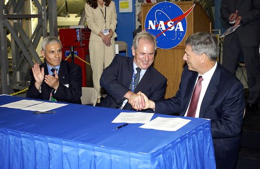 KENNEDY SPACE CENTER, FLA. - At a ceremony highlighting the arrival of two major components of the International Space Station, Node 2 and the Japanese Experiment Module (JEM), ownership of Node 2 was officially transferred between the European Space Agency (ESA) and NASA.  Shaking hands after the s