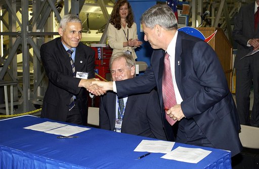 KENNEDY SPACE CENTER, FLA. - At a ceremony highlighting the arrival of two major components of the International Space Station, Node 2 and the Japanese Experiment Module (JEM), ownership of Node 2 was officially transferred between the European Space Agency (ESA) and NASA.  Shaking hands after the s