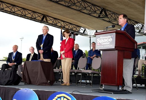 KENNEDY SPACE CENTER, FLA. -  At the KSC Visitor Complex, former astronaut Robert L. Crippen (right) presents former astronaut Sally K. Ride (standing center) at her induction ceremony into the U.S. Astronaut Hall of Fame. Also standing is former astronaut James A. Lovell.  Seated on the dais are, f