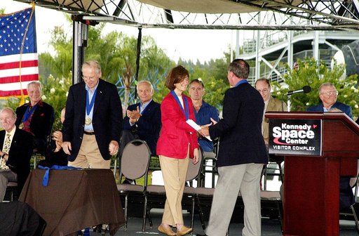 KENNEDY SPACE CENTER, FLA. -  At the KSC Visitor Complex, former astronaut Robert L. Crippen (standing right) congratulates former astronaut Sally K. Ride at her induction ceremony into the U.S. Astronaut Hall of Fame. Also standing is former astronaut James A. Lovell.  Seated on the dais, from left