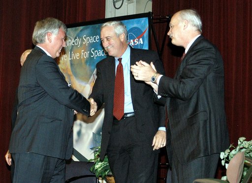 KENNEDY SPACE CENTER, FLA. -  KSC Deputy Director James W. Kennedy (left) and NASA Administrator Sean O'Keefe shake hands before a group of KSC employees assembled in the KSC Training Auditorium.  NASA Associate Administrator for Space Flight William F. Readdy applauds, at right. The occasion is the