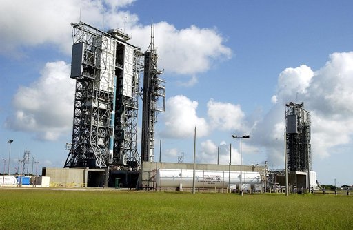 KENNEDY SPACE CENTER, FLA. -  On Launch Complex 17-B, Cape Canaveral Air Force Station, the first stage of a Delta II rocket is lifted up the mobile service tower.  In the background is pad 17-A.   The rocket is being erected to launch the Space InfraRed Telescope Facility (SIRTF).  Consisting of an