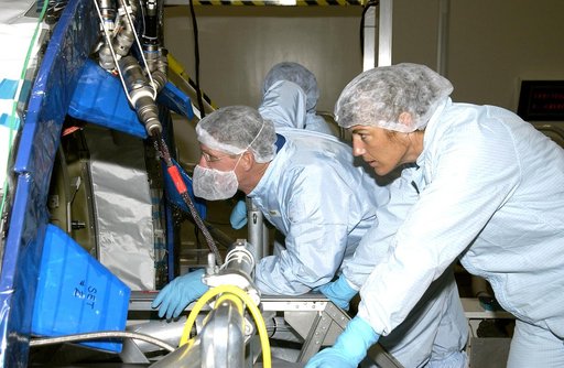KENNEDY SPACE CENTER, FLA. -  In the Space Station Processing Facility, STS-115 Mission Specialists Joseph Tanner (left) and Heidemarie Stefanyshyn-Piper (right)  look over the Japanese Experiment Module (JEM) Pressurized Module located in the Space Station Processing Facility. Known as Kibo, the JE