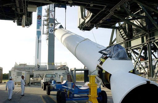 KENNEDY SPACE CENTER, FLA. -   A solid rocket booster (SRB) for the Delta II Heavy rocket that will launch the Space Infrared Telescope Facility (SIRTF) is lifted off its transporter on Launch Complex 17-B, Cape Canaveral Air Force Station.  The SRB will be added to the launch vehicle in the backgro