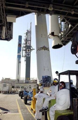 KENNEDY SPACE CENTER, FLA. -   Another solid rocket booster (SRB) is lifted to vertical on Launch Complex 17-B, Cape Canaveral Air Force Station, to join the one already in place in the mobile service tower.  The SRBs will be attached to the Delta II Heavy rocket in the background that will launch t