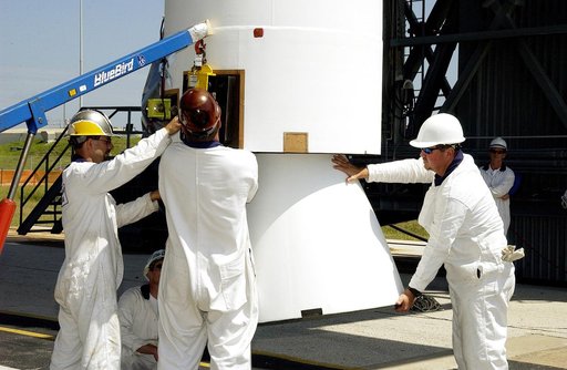 KENNEDY SPACE CENTER, FLA. -   Workers on Launch Complex 17-B, Cape Canaveral Air Force Station, help steady a solid rocket booster (SRB) being lifted into the mobile service tower.  It is one of nine  46-inch-diameter, stretched SRBs that are being attached to the Delta II Heavy rocket that will la