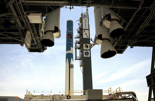KENNEDY SPACE CENTER, FLA. -   On Launch Complex 17-B, Cape Canaveral Air Force Station, the Delta II Heavy rocket  (background) is framed by the solid rocket boosters (foreground) suspended in the mobile service tower.  The SRBs will be added to those already attached to the rocket.  The Delta II H