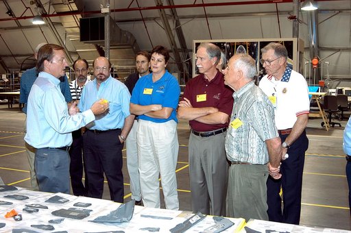 KENNEDY SPACE CENTER, FLA.  -  In the Columbia Debris Hangar, Shuttle Launch Director Mike Leinbach (left) talks to members of the  Stafford-Covey Return to Flight Task Group (SCTG) about reconstruction efforts.   Chairing the task group are Richard O. Covey (second from right), former Space Shuttle