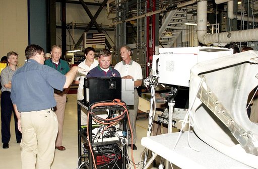 KENNEDY SPACE CENTER, FLA.  -  Members of the  Stafford-Covey Return to Flight Task Group (SCTG) look over equipment in the Orbiter Processing Facility.  At left (back to camera), Fernando Santos, with NASA, and Paul Ogletree (at monitor), with United Space Alliance, describe how flash thermography 
