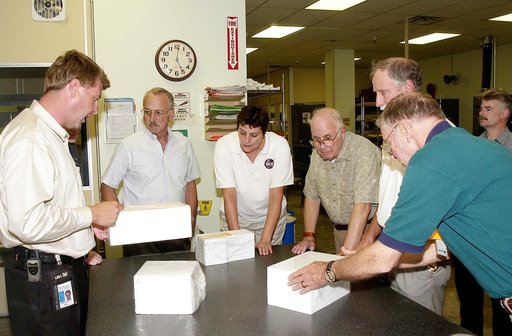 KENNEDY SPACE CENTER, FLA.  -  On a tour of the Tile Shop, members of the Stafford-Covey Return to Flight Task Group (SCTG) learn about PU-tiles, part of an orbiter’s Thermal Protection System.   At left is Martin Wilson, with United Space Alliance.  Others (left to right) around the table are James