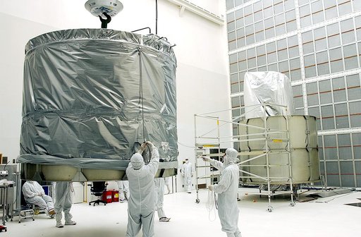 KENNEDY SPACE CENTER, FLA.  - Workers at Hangar A&E, Cape Canaveral Air Force Station, lift the upper canister to move it to the Space Infrared Telescope Facility (SIRTF) at right.  After encapsulation, the spacecraft will be transported to Launch Complex 17-B for mating with its launch vehicle, the
