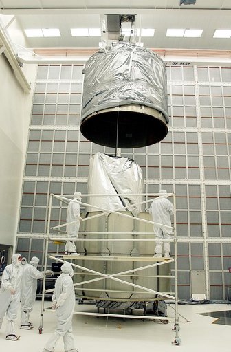 KENNEDY SPACE CENTER, FLA.  -  In Hangar A&E, Cape Canaveral Air Force Station, the upper canister is lowered toward the Space Infrared Telescope Facility (SIRTF) below.  After encapsulation is complete, the spacecraft will be transported to Launch Complex 17-B for mating with its launch vehicle, th