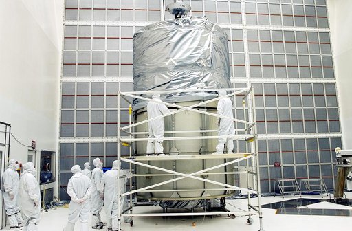 KENNEDY SPACE CENTER, FLA.  -  Working from a stand, technicians fasten the upper portion of the canister to the middle panels around the Space Infrared Telescope Facility (SIRTF).  The spacecraft will be transported to Launch Complex 17-B for mating with its launch vehicle, the Delta II rocket.   S