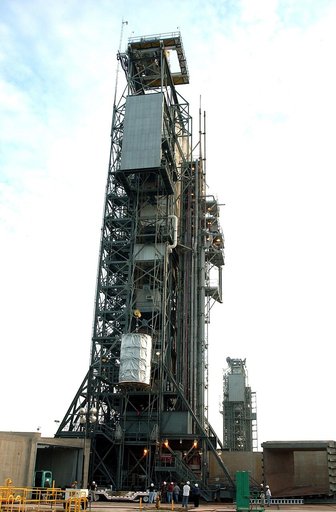 KENNEDY SPACE CENTER, FLA.  -  After dawn,  the Space Infrared Telescope Facility (SIRTF) is lifted up the mobile service tower on Launch Pad 17-B, Cape Canaveral Air Force Station.  SIRTF will be attached to the Delta II rocket and encapsulated in its fairing before launch.   Consisting of three cr