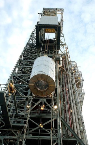 KENNEDY SPACE CENTER, FLA.  -  Viewed from below, the Space Infrared Telescope Facility (SIRTF) is lifted up the mobile service tower on Launch Pad 17-B, Cape Canaveral Air Force Station.  SIRTF will be attached to the Delta II rocket and encapsulated in its fairing before launch.   Consisting of th