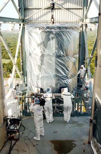 KENNEDY SPACE CENTER, FLA.  -  Workers on the mobile service tower on Launch Pad 17-B, Cape Canaveral Air Force Station, wait for the Space Infrared Telescope Facility (SIRTF) to reach their level.  SIRTF will be attached to the Delta II rocket and encapsulated in its fairing before launch.   Consis