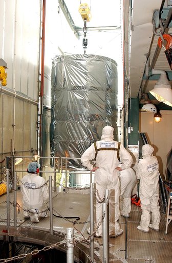 KENNEDY SPACE CENTER, FLA.  -  Workers on the mobile service tower on Launch Pad 17-B, Cape Canaveral Air Force Station, watch as the Space Infrared Telescope Facility (SIRTF) clears the platform.   SIRTF will be attached to the Delta II rocket and encapsulated in its fairing before launch.   Consis