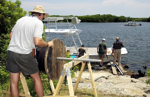 KENNEDY SPACE CENTER, FLA.  -  Research team members roll out acoustic cable to the water's edge during underwater acoustic research being conducted in the Launch Complex 39 turn basin.  Several government agencies, including NASA, NOAA, the Navy, the Coast Guard, and the Florida Fish and Wildlife C