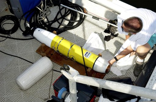 KENNEDY SPACE CENTER, FLA.  -  A research team member aboard one of the watercraft being utilized to conduct underwater acoustic research in the Launch Complex 39 turn basin prepares some of the project's equipment for placement in the water.  Several government agencies, including NASA, NOAA, the N