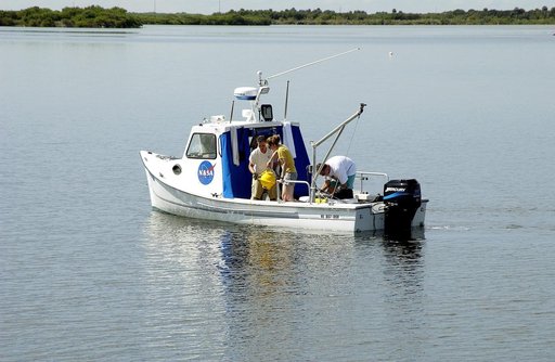 KENNEDY SPACE CENTER, FLA.  -  Research team members aboard one of the watercraft being utilized to conduct underwater acoustic research in the Launch Complex 39 turn basin prepare to release some of the project's equipment into the water.  Several government agencies, including NASA, NOAA, the Navy