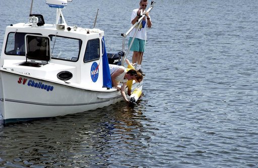 KENNEDY SPACE CENTER, FLA.  -  Research team members aboard one of the watercraft being utilized to conduct underwater acoustic research in the Launch Complex 39 turn basin release some of the project's equipment into the water.  Several government agencies, including NASA, NOAA, the Navy, the Coast