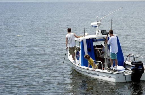 KENNEDY SPACE CENTER, FLA.  -  Research team members aboard one of the watercraft being utilized to conduct underwater acoustic research in the Launch Complex 39 turn basin monitor some of the project's equipment just released into the water.  Several government agencies, including NASA, NOAA, the N