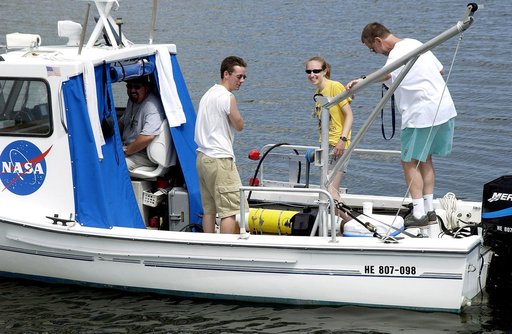 KENNEDY SPACE CENTER, FLA.  -  Research team members aboard one of the watercraft being utilized to conduct underwater acoustic research in the Launch Complex 39 turn basin secure some of the project's equipment back into the vessel.  Several government agencies, including NASA, NOAA, the Navy, the 