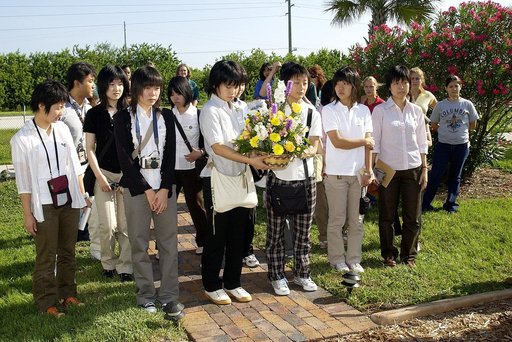 KENNEDY SPACE CENTER, FLA.  -   Japanese girls from Urawa Daiichi Girls High School, Urawa, Japan, carry a floral tribute to the crew of Columbia to place at the STS-107 memorial stone at the Spacehab facility, Cape Canaveral, Fla.   The group was  awarded the trip to Florida when their experiments 