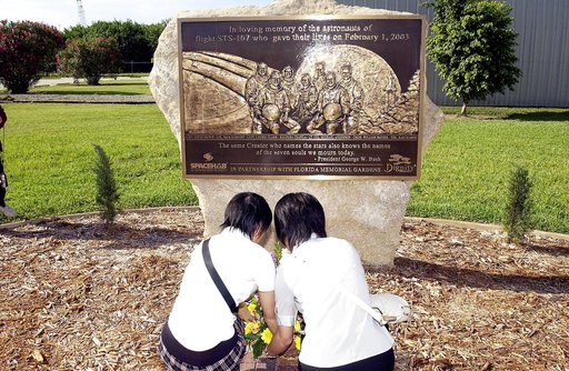 KENNEDY SPACE CENTER, FLA.  -   Japanese girls from Urawa Daiichi Girls High School, Urawa, Japan, place a floral tribute to the crew of Columbia at the STS-107 memorial stone at the Spacehab facility, Cape Canaveral, Fla.   The group was  awarded the trip to Florida when their experiments were chos
