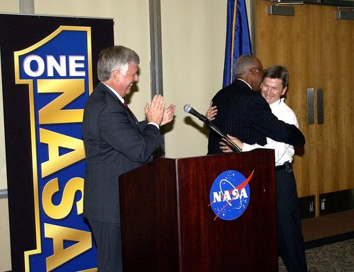 KENNEDY SPACE CENTER, FLA.  -   At the rollout of the One NASA initiative at KSC, Glenn Research Center Director Dr. Julian Earls embraces implementation team lead Johnny Stevenson while KSC Director Jim Kennedy (left) applauds.  Earls gave a motivational speech during the luncheon held at the Visit