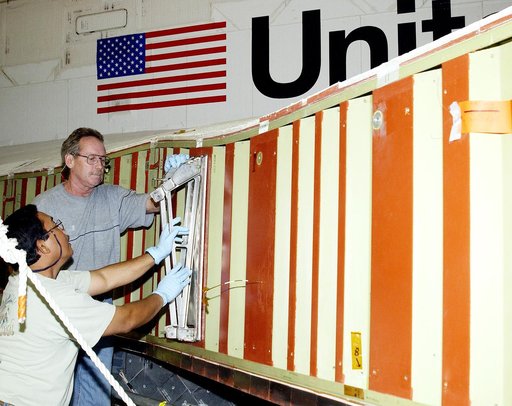 KENNEDY SPACE CENTER, FLA. -  Mike Hyatt (left) and Saul Ngy, technicians with United Space Alliance, prepare to install a spar on the wing of the orbiter Atlantis.  The Reinforced Carbon Carbon (RCC) panels are mechanically attached to the wing with a series of floating joints - spars - to reduce l