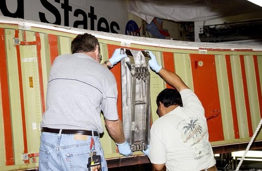 KENNEDY SPACE CENTER, FLA. -  Mike Hyatt (left) and Saul Ngy, technicians with United Space Alliance, install a spar on the wing of the orbiter Atlantis.  The Reinforced Carbon Carbon (RCC) panels are mechanically attached to the wing with a series of floating joints - spars - to reduce loading on t
