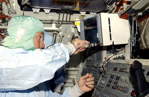 KENNEDY SPACE CENTER, FLA.  -   A technician with United Space Alliance works inside orbiter Discovery before power-up of the vehicle in the Orbiter Processing Facility .  Discovery has been undergoing Orbiter Major Modifications in the past year, ranging from wiring, control panels and black boxes 