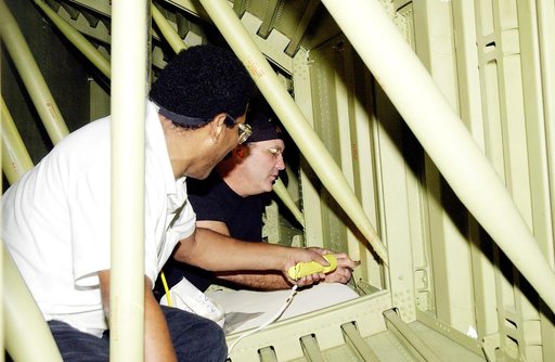 KENNEDY SPACE CENTER, FLA. - In the Orbiter Processing Facility (OPF), United Space Alliance technicians replace the attachment points for the spars on the interior of a wing of Space Shuttle Atlantis. Reinforced Carbon Carbon (RCC) panels are mechanically attached to the wing with a series of float
