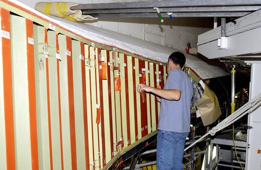 KENNEDY SPACE CENTER, FLA. - In the Orbiter Processing Facility (OPF), a United Space Alliance technician examines the attachment points for the spars on the exterior of a wing of Space Shuttle Atlantis. Reinforced Carbon Carbon (RCC) panels are mechanically attached to the wing with a series of flo