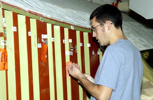 KENNEDY SPACE CENTER, FLA. -In the Orbiter Processing Facility (OPF), a United Space Alliance technician examines the attachment points for the spars on the exterior of a wing of Space Shuttle Atlantis. Reinforced Carbon Carbon (RCC) panels are mechanically attached to the wing with a series of floa