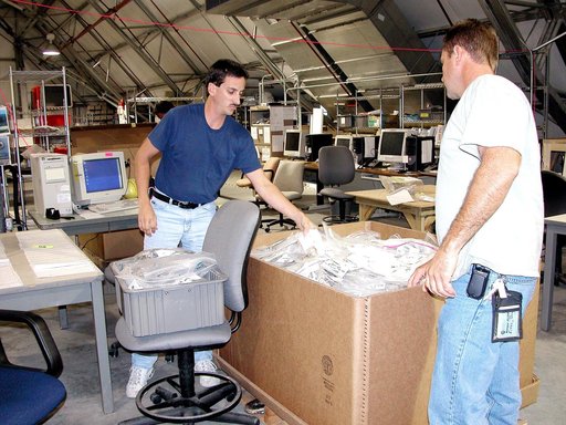 KENNEDY SPACE CENTER, FLA.  -  Workers in the Columbia Debris Hangar move some of the STS-107 debris into boxes for transfer to storage in the Vehicle Assembly Building.   About 83,000 pieces were shipped to KSC during search and recovery efforts in East Texas.